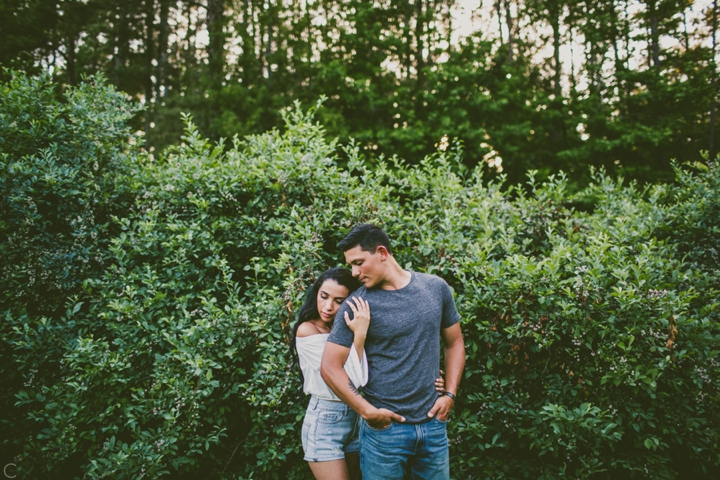 Couple standing in front of bushes