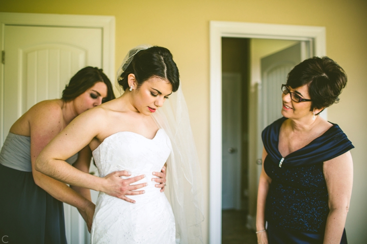 Bride putting on dress