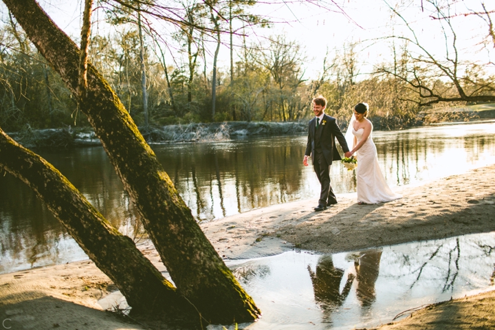 Bride and groom walking down beach