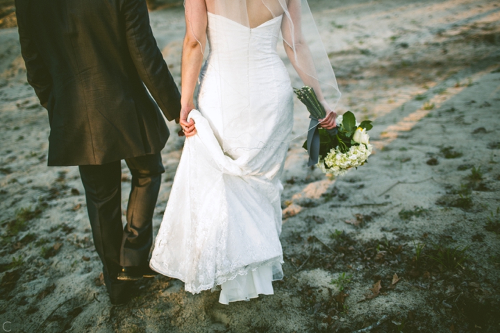 Bride and groom walking in sand
