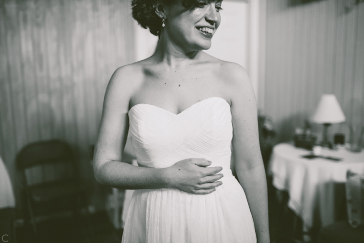 Bride putting on dress