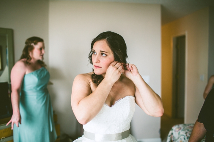 Bride putting on earrings