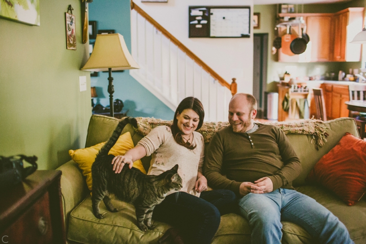 Couple sitting on couch with cat