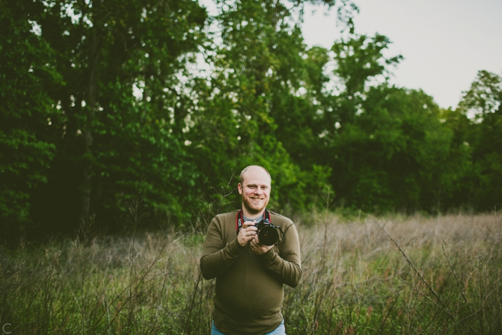 Man standing in field with camera