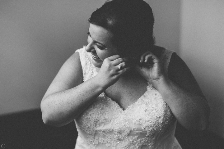 Bride putting on earrings