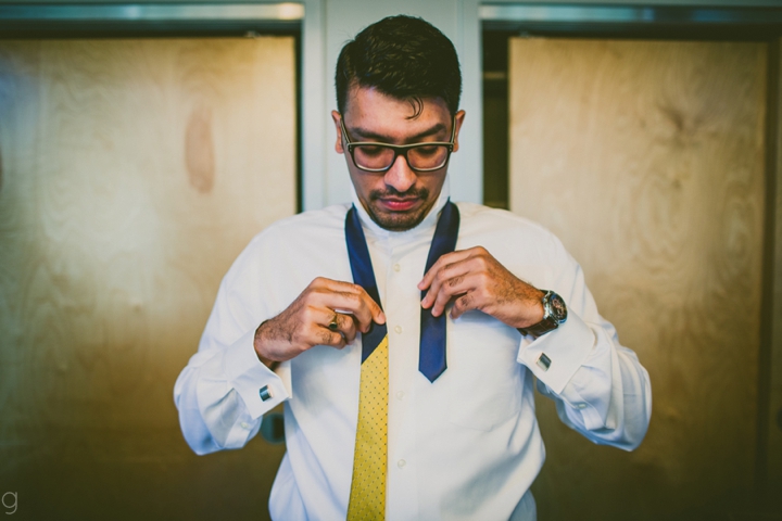 Groom putting on tie