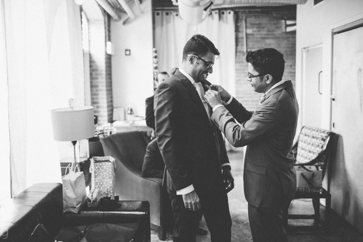 Groom putting on tie