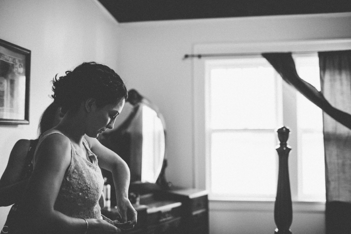 Bride putting on dress