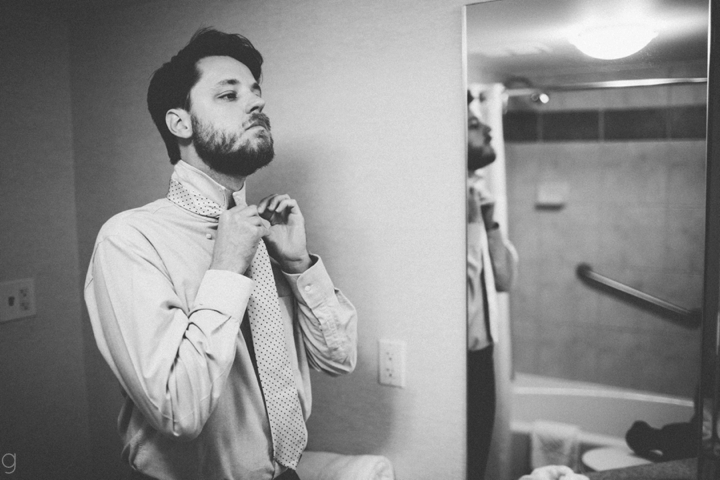 Groom putting on tie