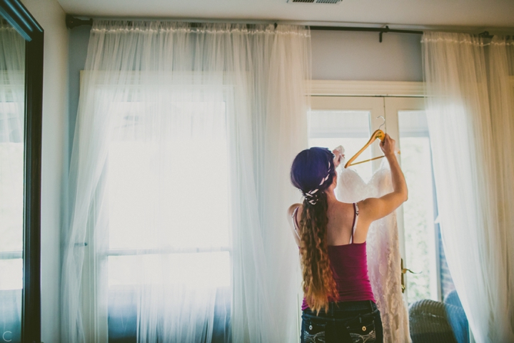 Bride getting dress off hanger