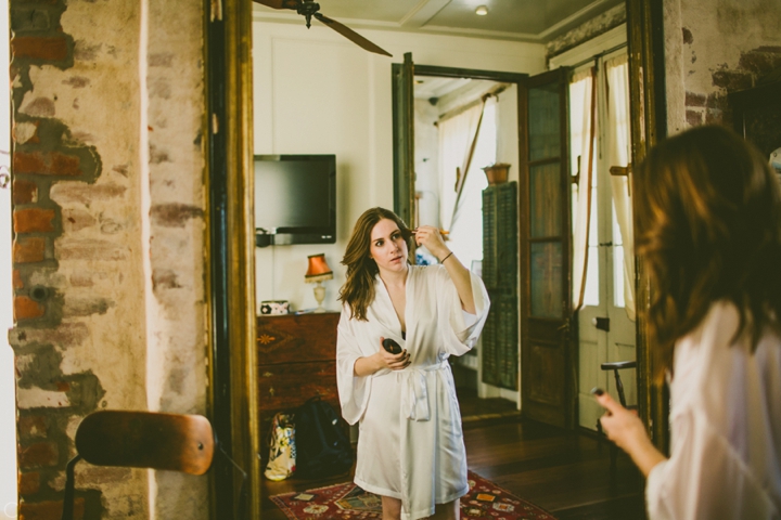 Bride putting on makeup in mirror