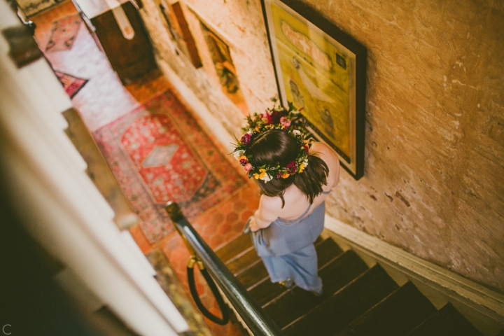 Bride in flower crown walking down stairs