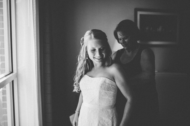 bride putting on wedding dress