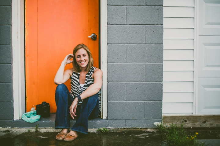 Girl sitting on stoop with orange door