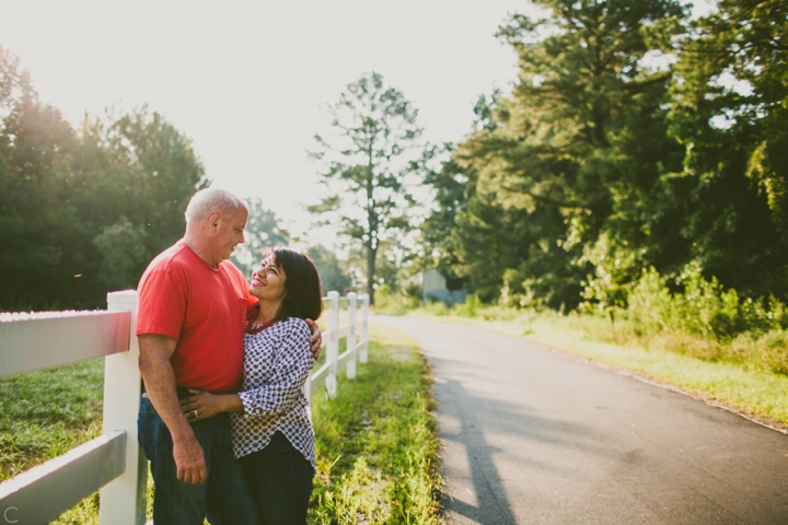 Husband and wife standing by white picket fence