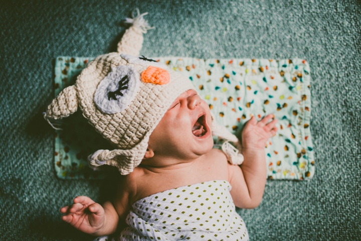 Baby crying in owl hat