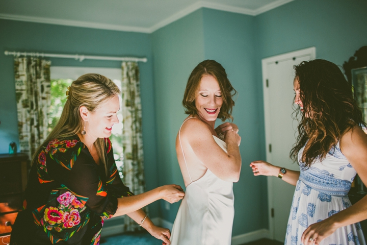 Bride putting on dress