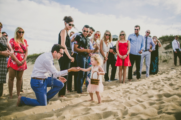 Flower girl handing seashell to guest