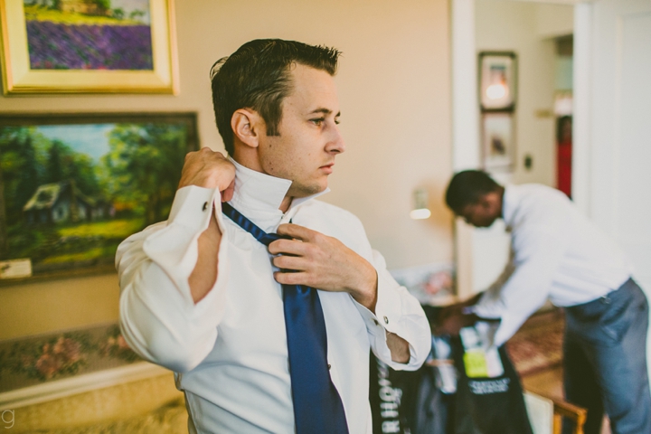 Groom putting on tie