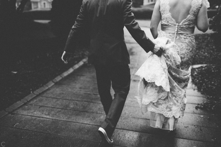 Groom holding bride's dress