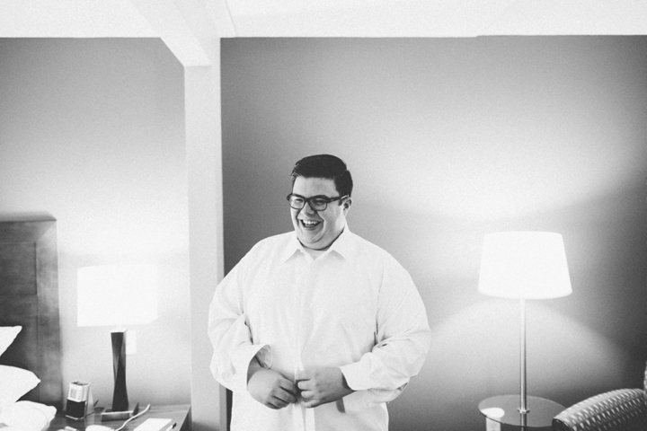 Groom buttoning his shirt