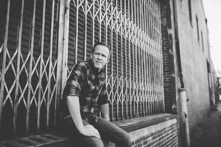 Man sitting by metal grate