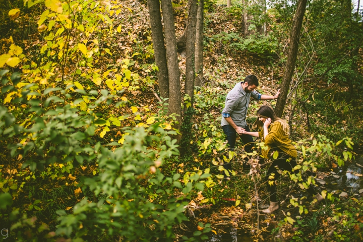 Husband helping wife across creek