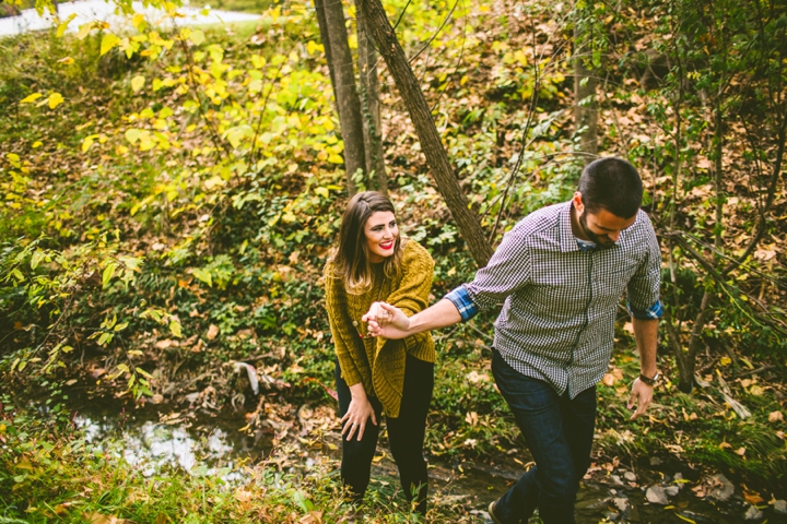 Husband helping wife across creek