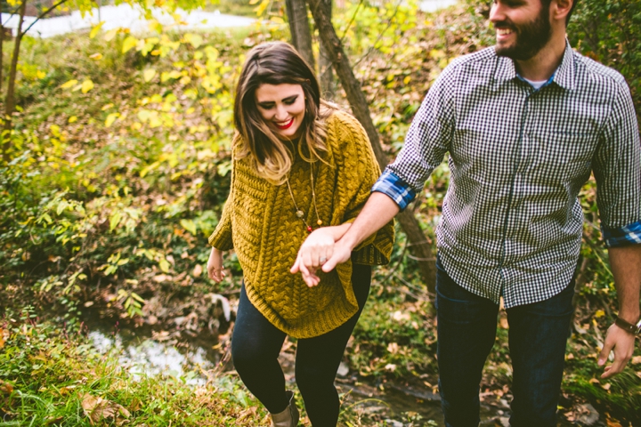 Husband helping wife across creek