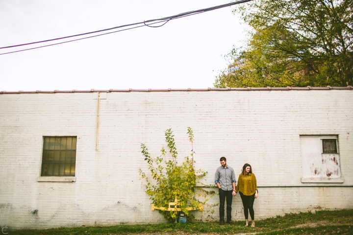 Couple standing next to wall in downtown Durham