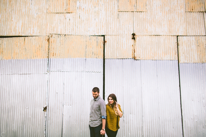 Husband and wife standing by wall near downtown Durham