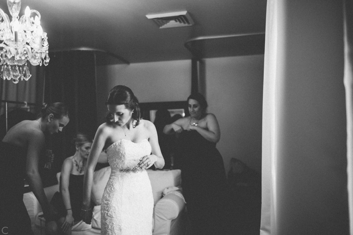 Bride putting on wedding dress