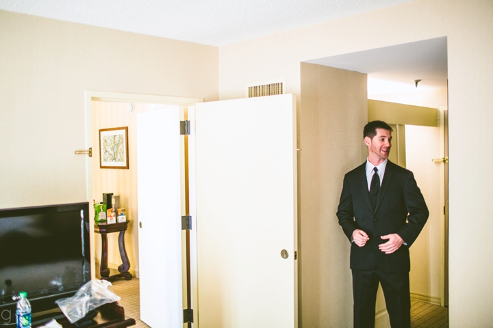 Groom standing in hotel room