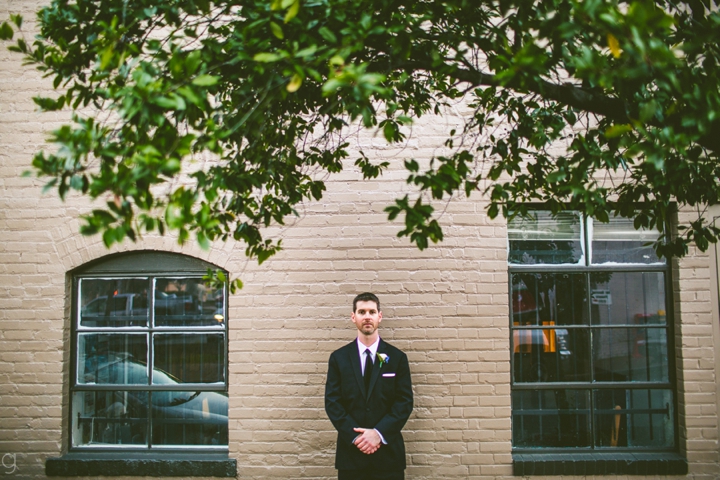Groom standing by wall for portrait