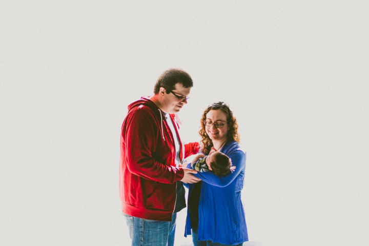 Family standing with newborn baby