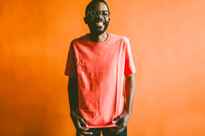 Man smiling against orange wall