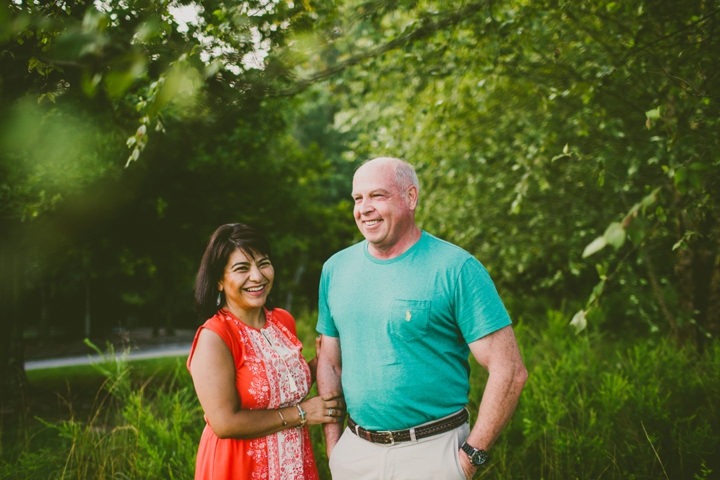 Couple standing and laughing by tree