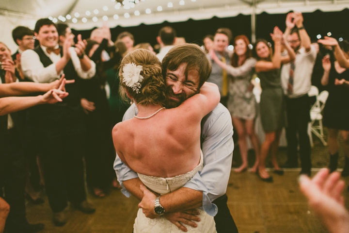 Husband hugging wife at wedding reception