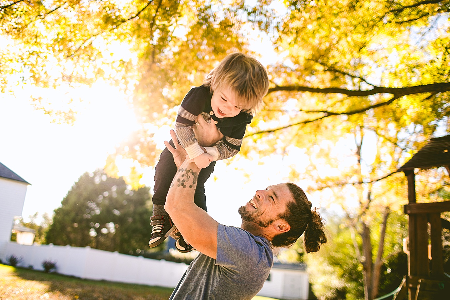 Dad tossing son up in the air during family photos in Raleigh