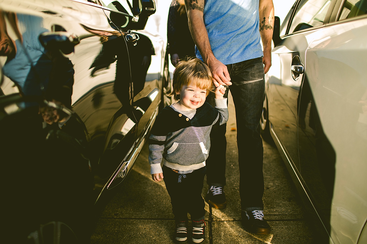 Toddler holding his dad's hand and walking