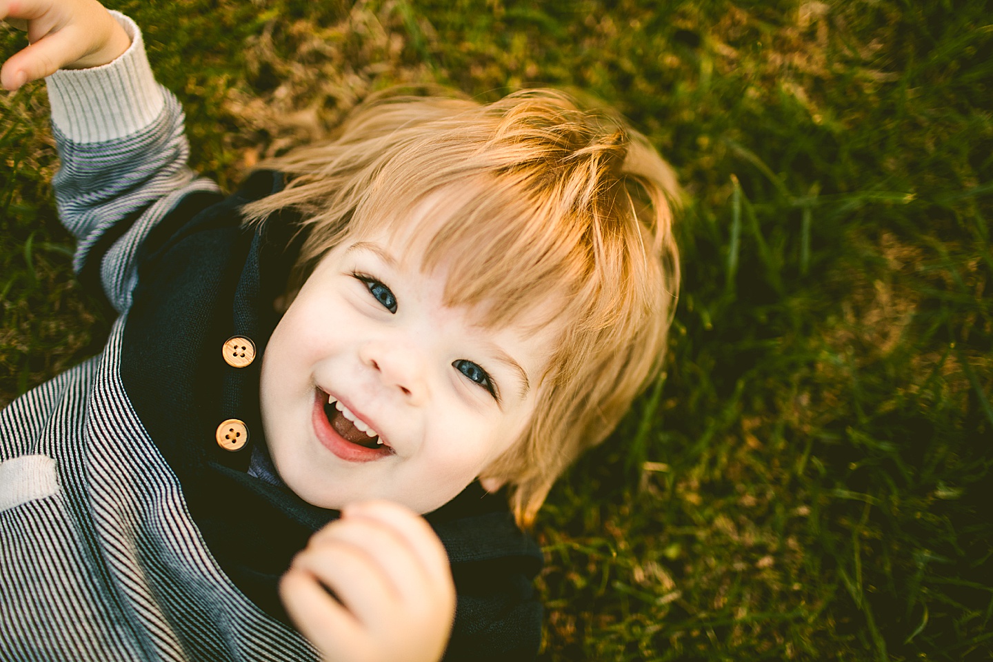 Toddler laughing on the grass