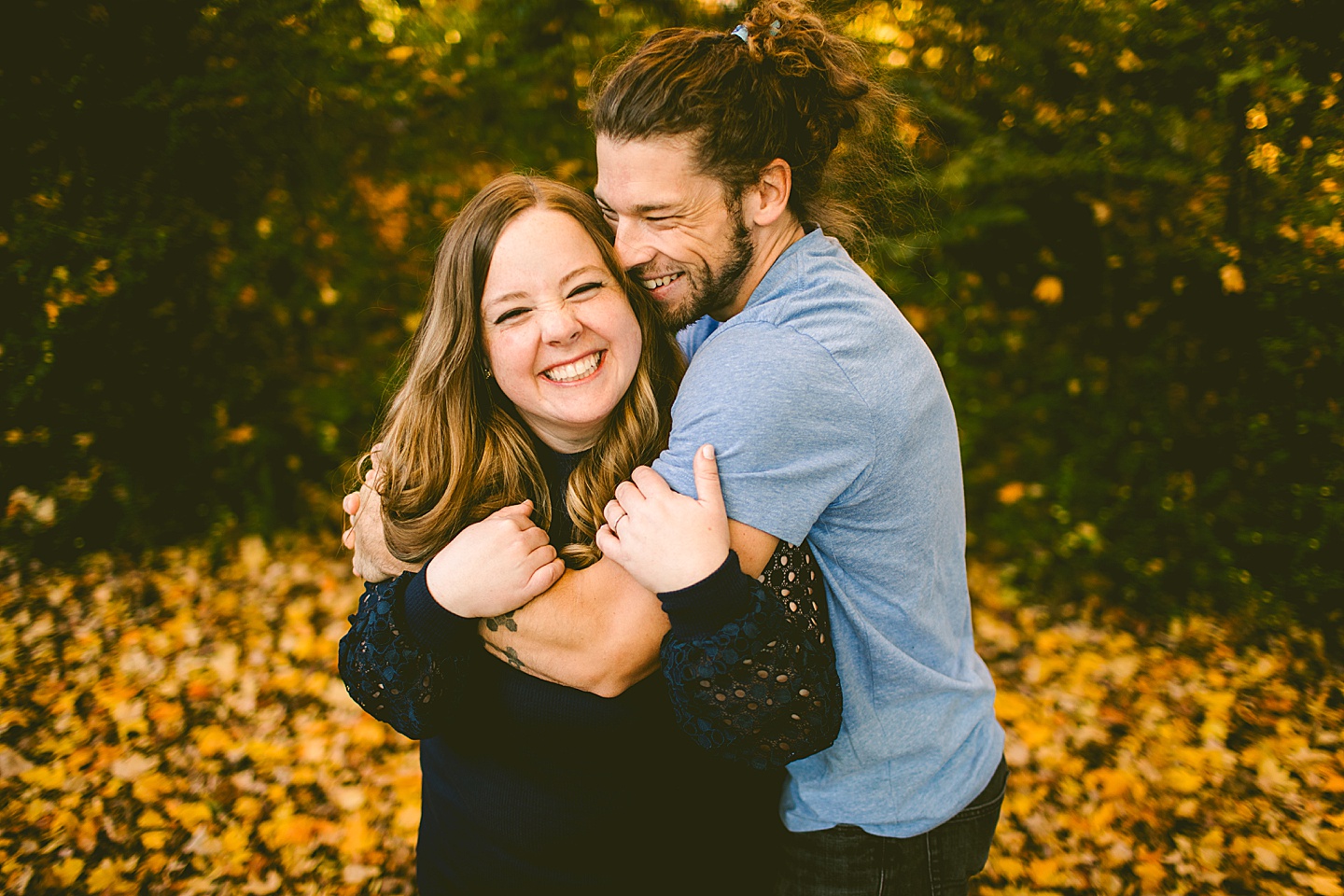 Couple laughing with fall leaves