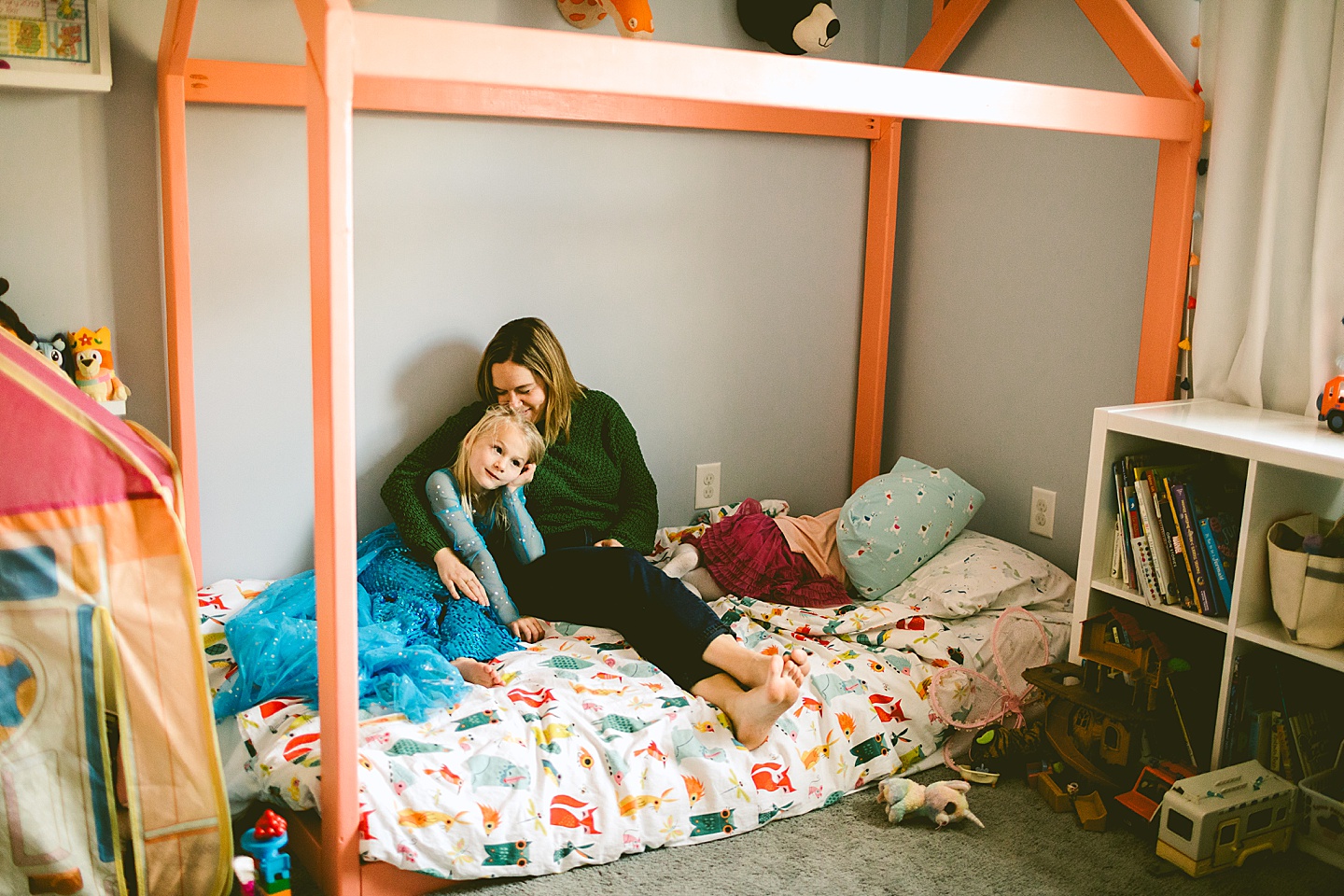 Mom sitting on bed with daughters