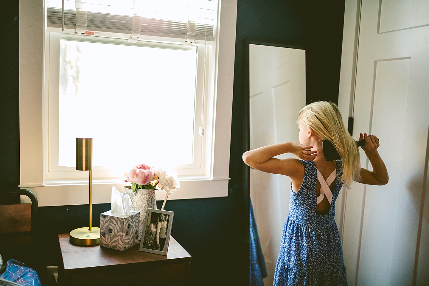 Girl brushing her hair in mirror