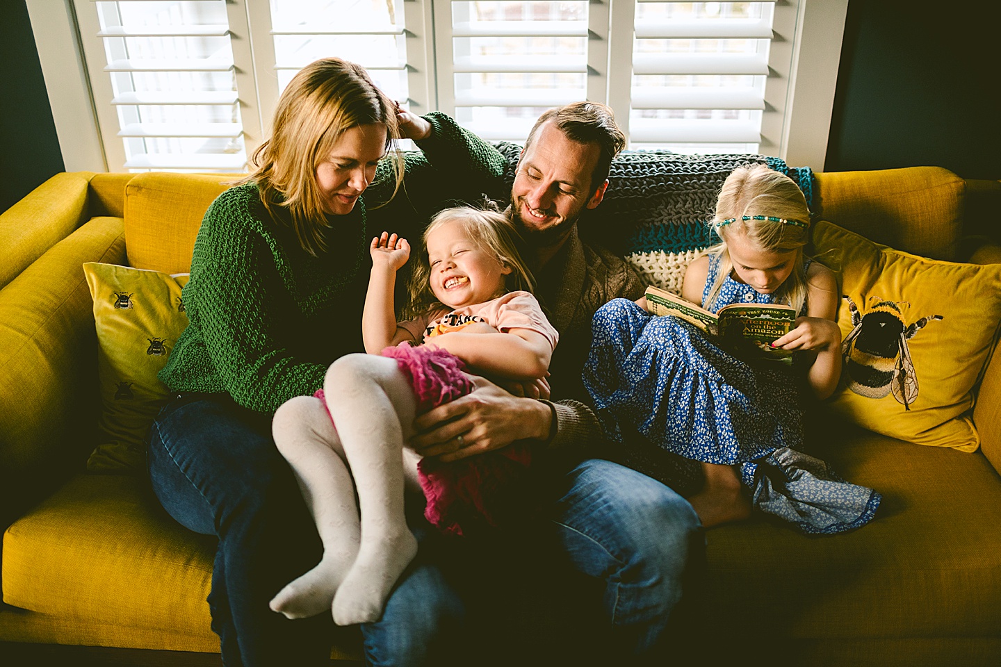 Family cuddling on couch in living room