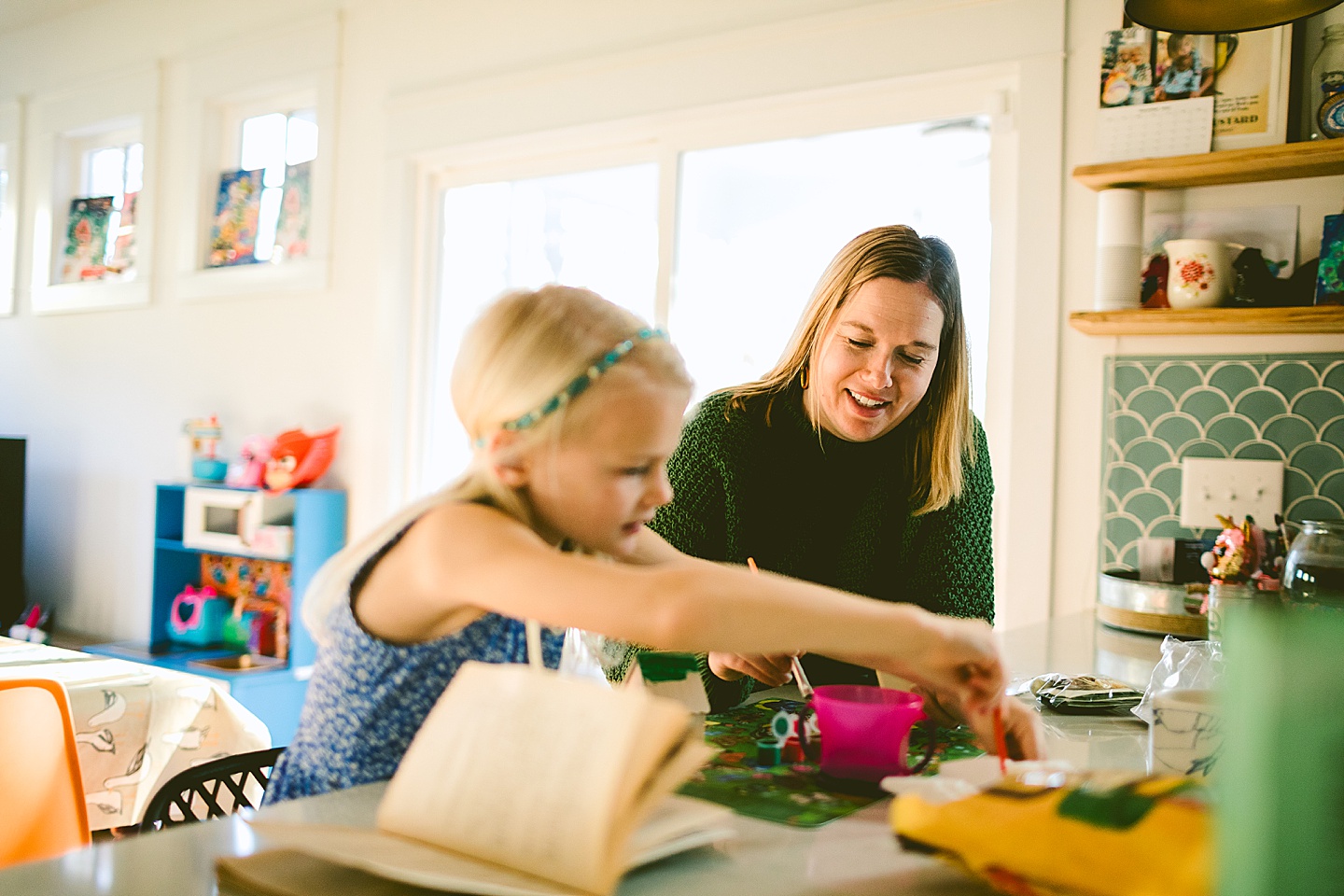 Daughter painting a holiday house with her mom