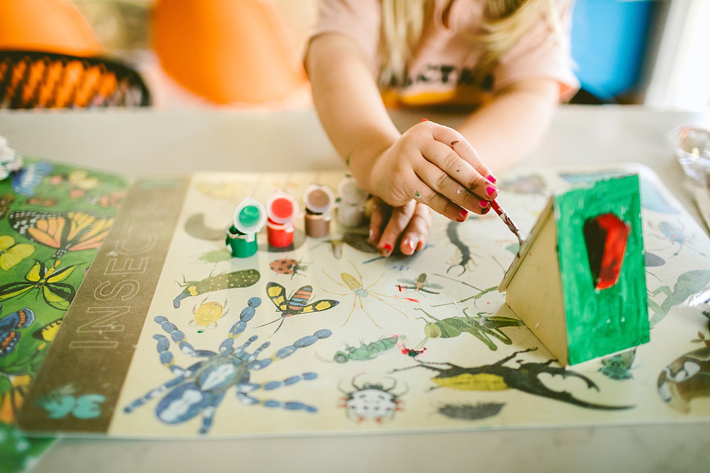 Little girl painting toy house