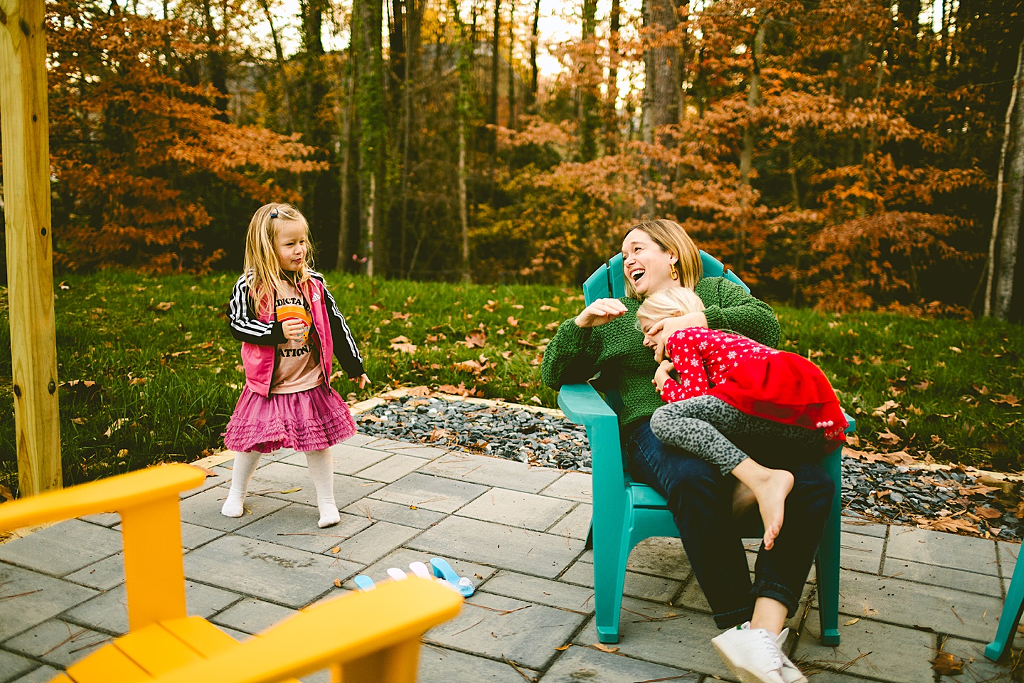 Mom laughing on a patio with daughters