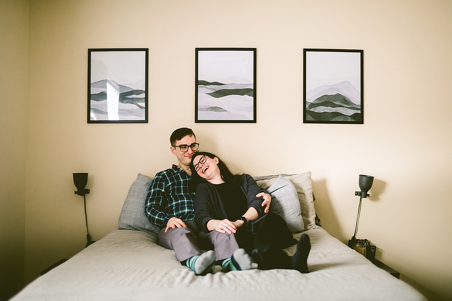 Couple laughing on bed in home in Raleigh NC