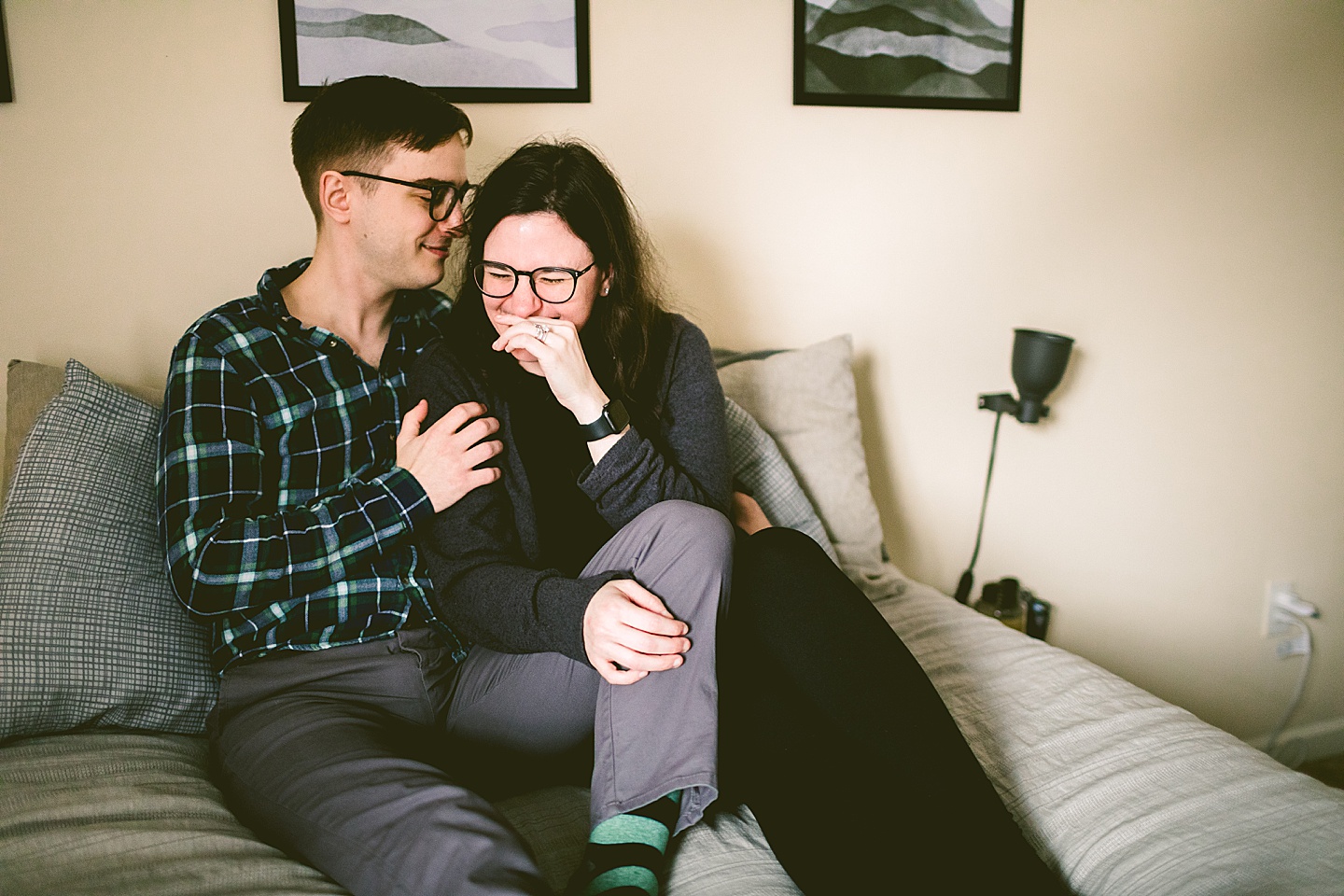 Couple laughing on bed in home in Raleigh NC